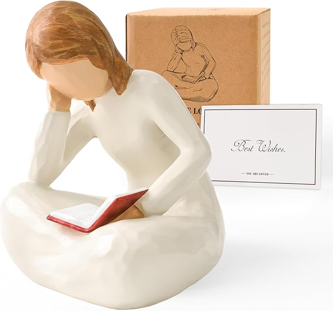 A statue of an girl sitting and reading a book.